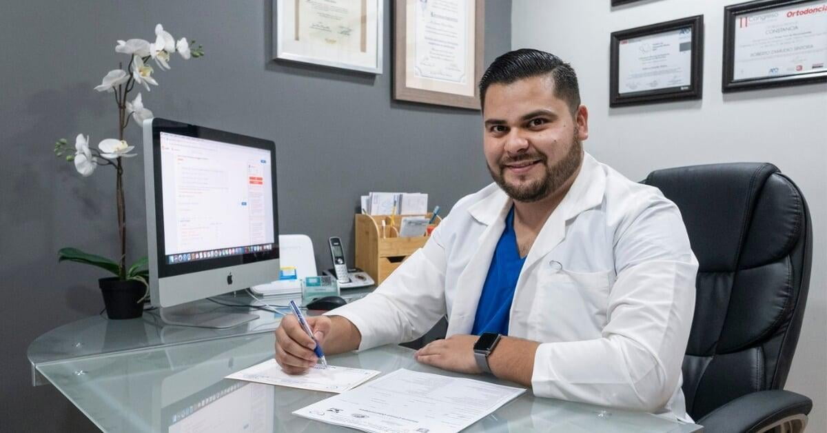 Smiling dentist at a desk.