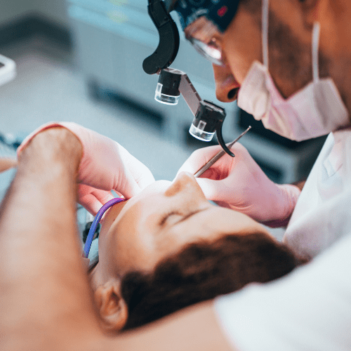 Patient lying in a dental chair examined by a dentist.