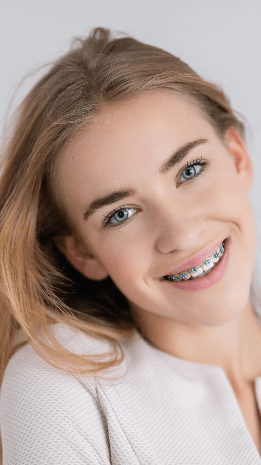 Smiling young woman individual with dental braces.